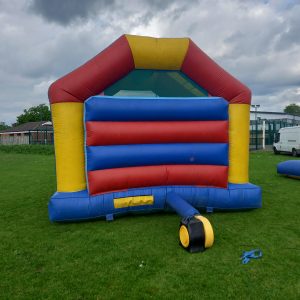 Red and blue inflatable bouncer with a yellow trim and a large entrance.