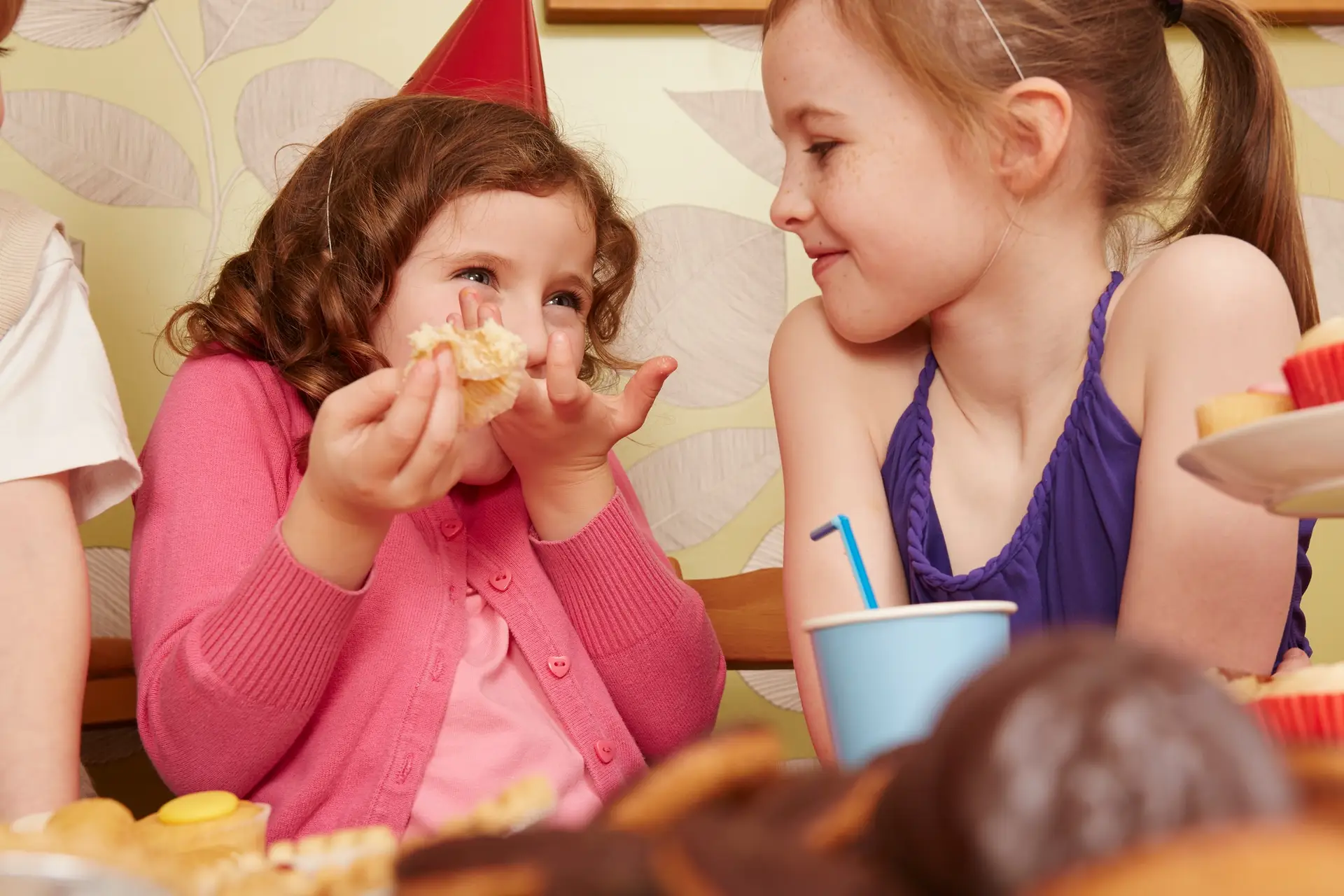 Girl eating party food with friend