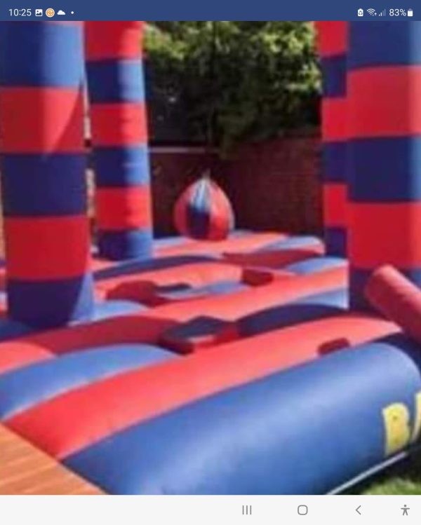 Inflatable battle zone with red and blue striped pillars and a central inflatable ball.