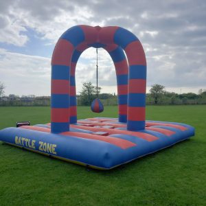 Inflatable Battle Zone structure with red and blue stripes and a hanging punching bag.