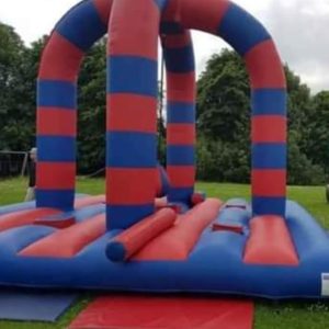 Red and blue inflatable bounce structure with vertical arches and a flat base.