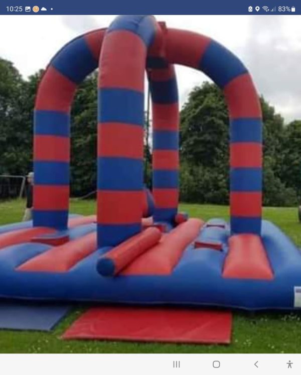 Red and blue inflatable bounce structure with vertical arches and a flat base.