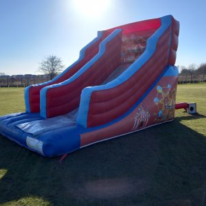 Large inflatable circus slide with colorful designs and two sliding lanes.