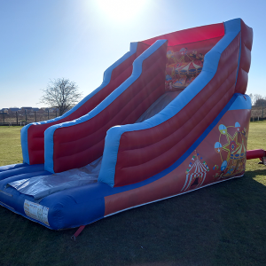 Circus-themed inflatable slide with red and blue colors, featuring two sliding lanes.