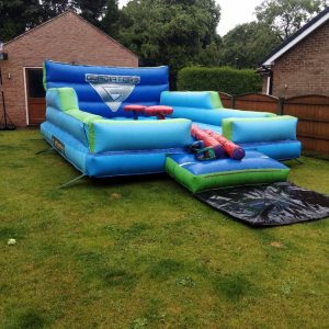 Inflatable gladiator obstacle course with blue and green sections and multiple platforms.