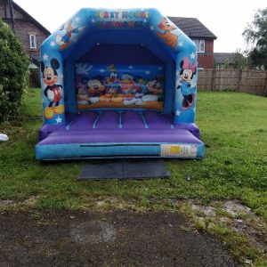 Mickey Mouse themed inflatable bounce house featuring characters from Disney.