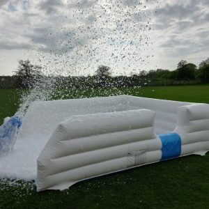 An inflatable foam cannon producing foam in an outdoor setting.