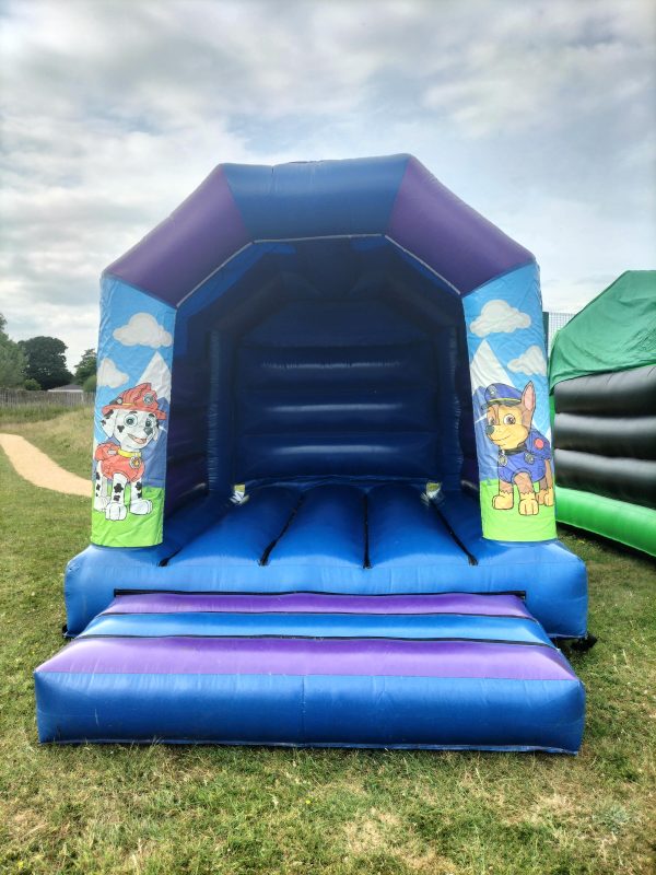 Paw Patrol themed bounce house featuring characters on the side and a blue interior.