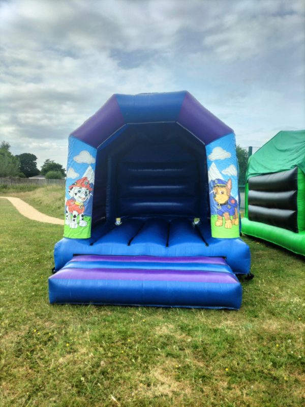 Paw Patrol themed inflatable bounce house with blue and purple colors and character designs.