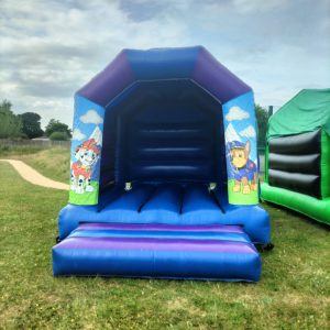 Paw Patrol themed inflatable bounce house with characters on the sides and a blue structure.