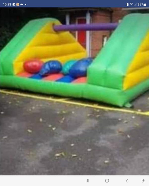 Inflatable Pillow Bash game featuring colorful padded areas and soft pillows in red, blue, and green.