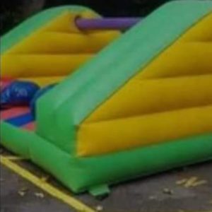 Inflatable Pillow Bash game featuring colorful green, yellow, and purple sections.