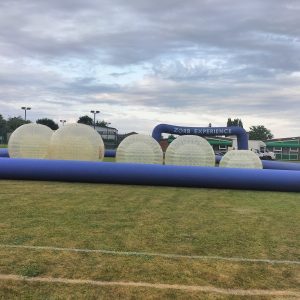 Inflatable Zorb balls and a blue inflatable entrance for a Zorb experience event.