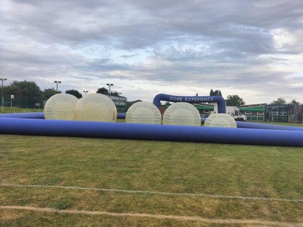 Inflatable Zorb balls and a blue inflatable entrance for a Zorb experience event.