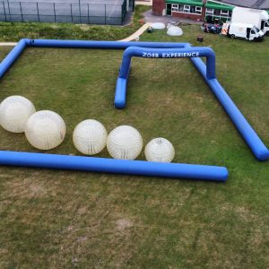 Inflatable Zorb experience area with large transparent Zorb balls and blue inflatable frame.