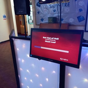 Karaoke monitor showing the song 'Bat Out of Hell' by Meat Loaf with a progress bar.