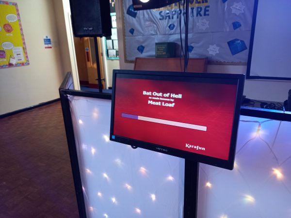 Karaoke monitor showing the song 'Bat Out of Hell' by Meat Loaf with a progress bar.