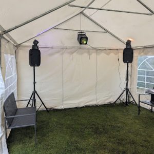 Interior view of a white gazebo featuring two speakers and stage lighting.