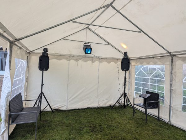 Interior view of a gazebo featuring two speakers and a light fixture mounted on the ceiling.