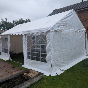 White outdoor party tent featuring large windows on the sides for visibility and ventilation.